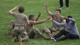 AFROTC members sitting on the ground and high-fiving