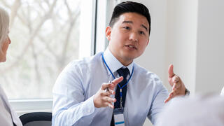 Man talking to colleagues at table