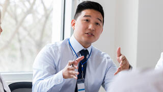 Man talking to colleagues at table