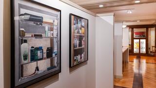 Gallery view with artwork hung on wall looking into the read of the gallery