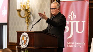 Fr. Lannon giving blessing at REC Luncheon