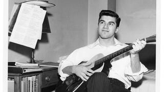 Student playing guitar in dorm room