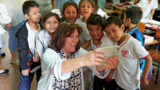 woman taking a selfie with Bolivian children