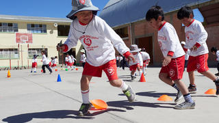 young boys playing a game outside of a school