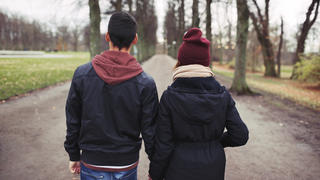 Stock image of two individuals holding hands 