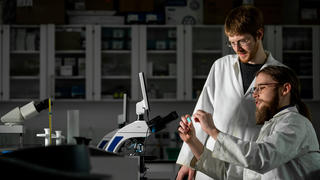 Garrett Walker ’23 and Jason Wallach, PhD, in the lab working on research