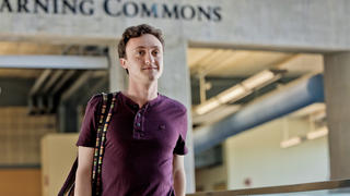 student walking inside a library