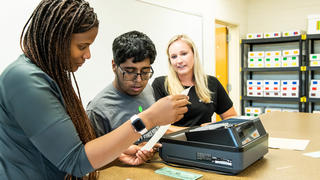 staff working with a student in a classroom setting