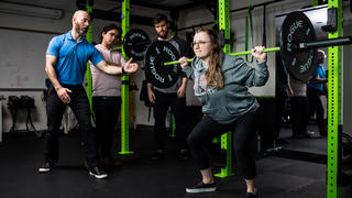 a college student lifting weights inside a kinesiology lab at Saint Joseph's University