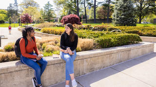 two students on saint joseph's university's campus, talking outside