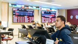 A business major inside the Wall Street Trading Room at Saint Joseph's University