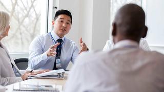 a hospital administrator talking to his colleagues