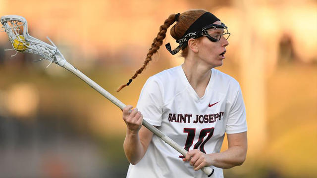 Lisa Ross, Saint Joseph's women's lacrosse player, holding stick with ball on the field