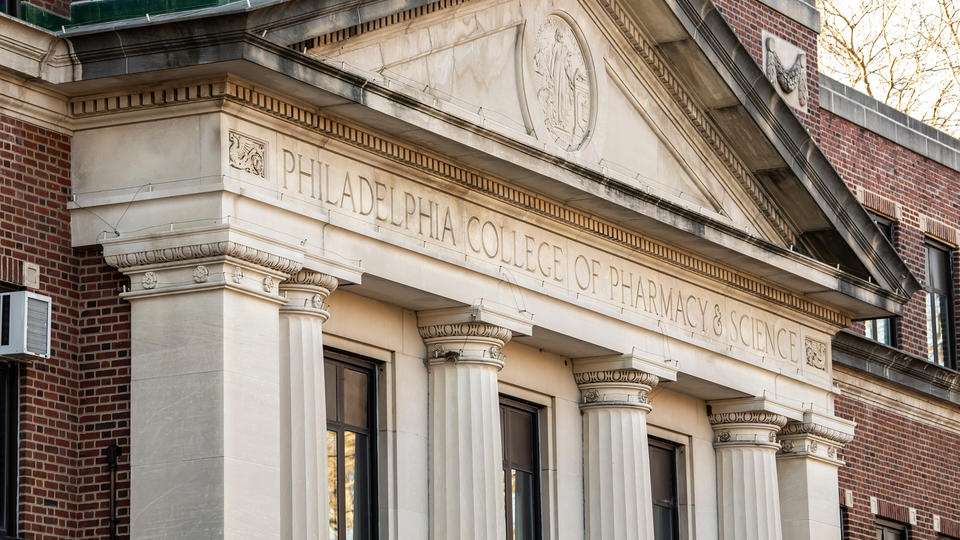 The Romanesque facade of the Philadelphia College of Pharmacy, Griffith Hall, with the name of the school spelled out in the frieze