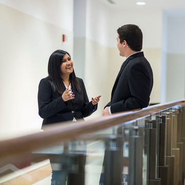 two young professionals talking in the hallway
