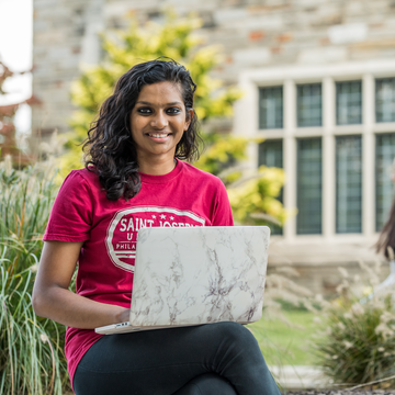 Undergraduate student on her laptop outside