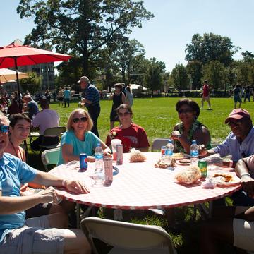 Family sitting at picnic eating a meal