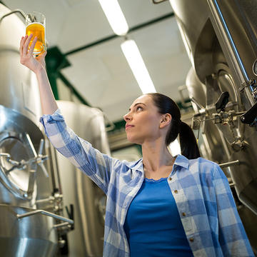 Person holding up a sample beer for Saint Joseph's University brewing certificate program.