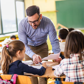 Teacher helping out elementary students in class