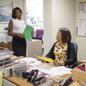 Two women in an office talking to one another