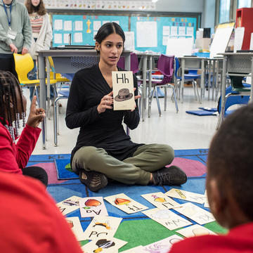 SJU student teacher in Gompers teaching students letters