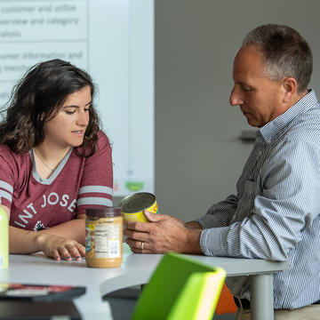 Professor and student discussing food products in food marketing lab