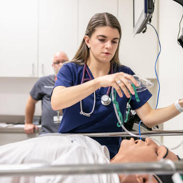 Saint Joseph's University health science student putting oxygen on practice dummy in lab