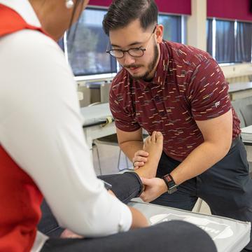 Physical therapy student learning to help a client