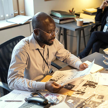 Man sitting behind desks looking at papers