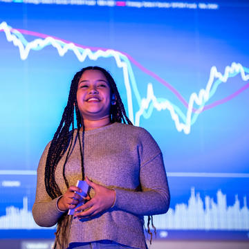 Saint Joseph's University economics student presenting with stat graph in the background