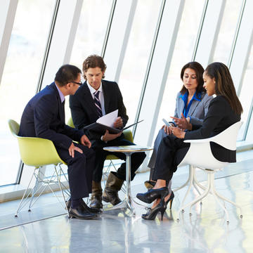 Diverse group of business professionals discussing work at a table