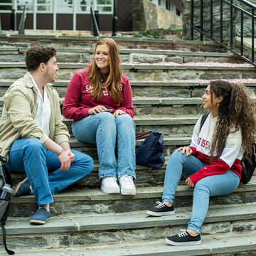 Group of Saint Joseph's students sitting on steps talking to one another