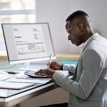 Male accountant working on an invoice on computer
