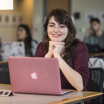 Female Saint Joseph's student on laptop in library