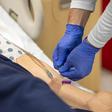 Nurse inserting IV into patient's arm