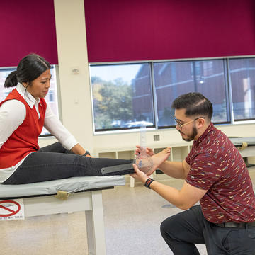 Physical Therapy student working alongside another PT students in lab