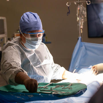 Female nurse setting up surgical equipment in operation room