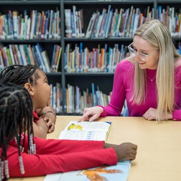 Student teacher educating young elementary school students in a classroom