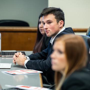 Student sitting at a desk with laptop in a classroom