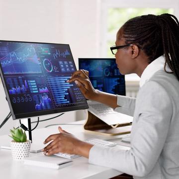 Woman pointing at a computer screen with data and graphs