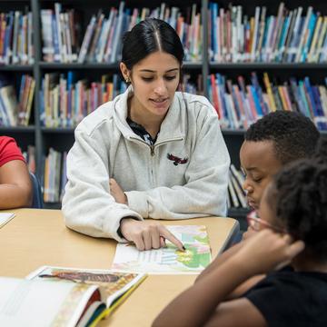 Student teacher educating young elementary school students in a classroom