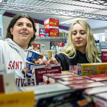 Two students organizing food in a pantry