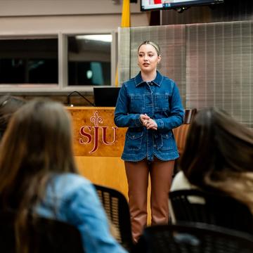 Student giving a speech in front of a group of people