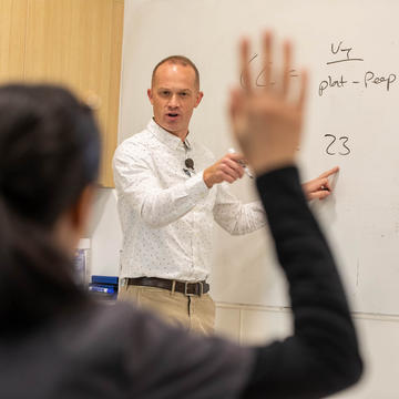 Teacher teaching students while using a whiteboard in a classroom