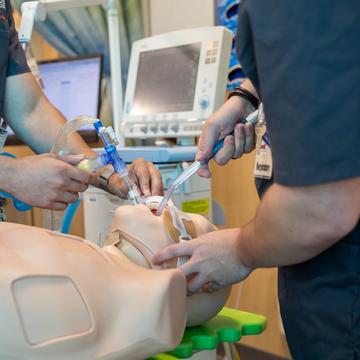 Medical students providing oxygen to a manikin