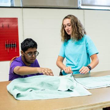 Woman teaching a student how to fold towels