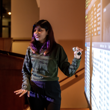 Woman teaching while pointing to a screen