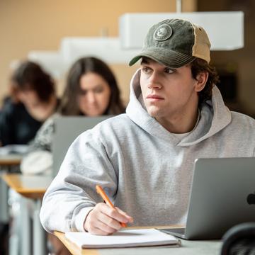 Student sitting in front of of a laptop in a library