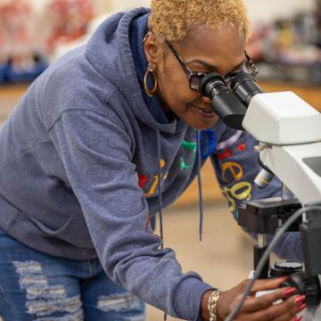 Student looking into a microscope in a lab