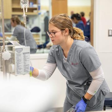 Nursing student setting up medical equipment